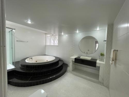 a bathroom with a tub and a sink and a mirror at Casa com vista pro Cristo Redentor in Niterói