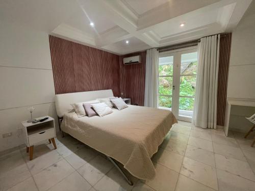 a bedroom with a bed and a large window at Casa com vista pro Cristo Redentor in Niterói