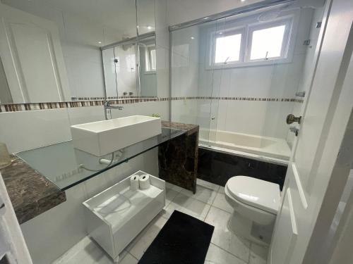 a white bathroom with a sink and a toilet at Casa com vista pro Cristo Redentor in Niterói