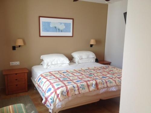 ein Schlafzimmer mit einem Bett und einem Bild an der Wand in der Unterkunft ADDAIA APARTMENT in Port d'Addaia