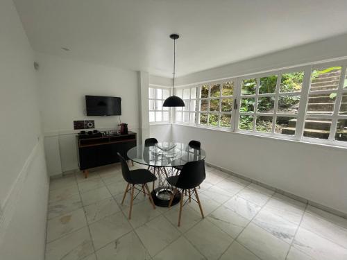 a dining room with a glass table and chairs at Casa com vista pro Cristo Redentor in Niterói