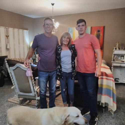 three people standing in a living room with a dog at Mi Lugar en el Mundo in Buenos Aires
