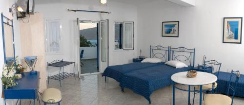 ÓrmosにあるVilla Lontorfouのベッドルーム(青いベッド1台、テーブル、椅子付)