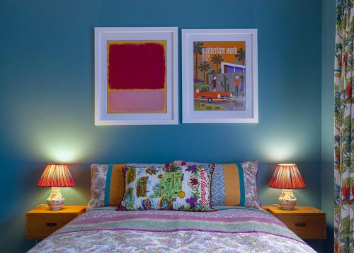 a blue bedroom with two lamps and a bed at Jamaica Mid-Century in Seaton