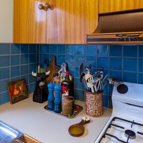 a kitchen counter with bottles and utensils on it at Jamaica Mid-Century in Seaton
