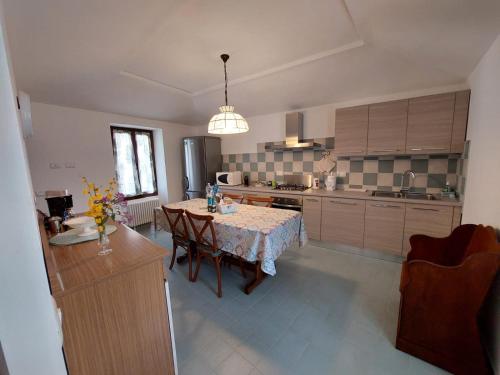 a kitchen with a table and a dining room at Casa Sassello - Appartamento Menta in Dumenza