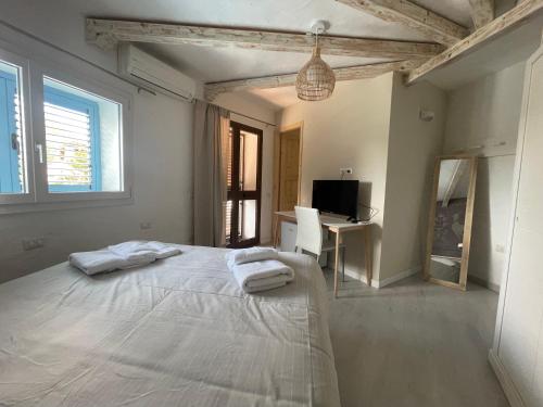 a white bedroom with a bed with towels on it at Domus de Diana in Olbia