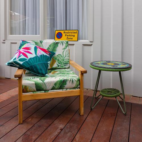 a couch and a side table on a wooden deck at Jamaica Mid-Century in Seaton