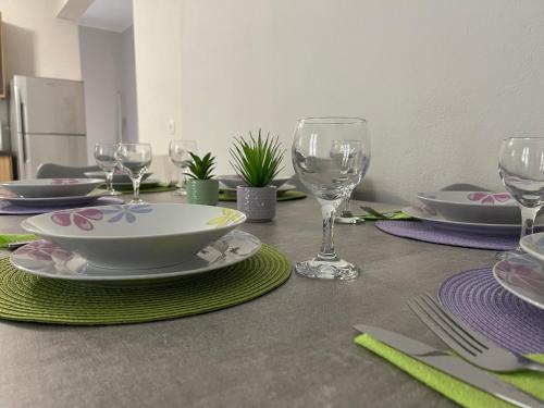 una mesa con platos y copas de vino. en Litsa's Apartment, en Igoumenitsa