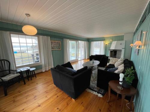 uma sala de estar com dois sofás e uma lareira em Summer house on Tjøme with beach and pier em Tjome