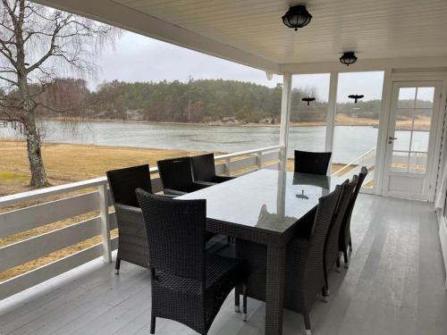 a table and chairs on a porch with a view of the water at Summer house on Tjøme with beach and pier in Tjøme