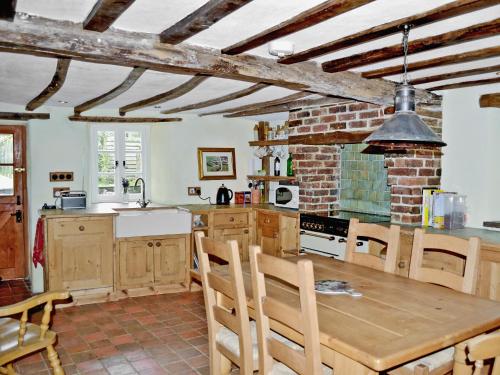 a kitchen with a wooden table and chairs in a room at Syncocks Farm in Petrockstow