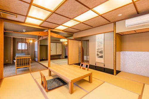 a room with a wooden table and chairs in it at Atarayo Nishiizu Onsen in Izu
