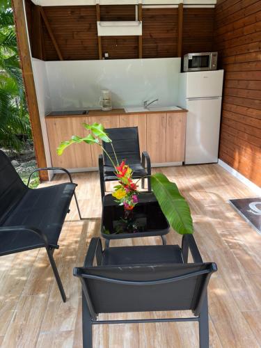 un patio avec deux chaises et une table ainsi qu'une cuisine dans l'établissement Nature et quiétude, à Le Moule