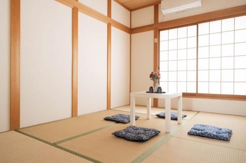 a room with a white table and two mats at 悠の宿 in Osaka