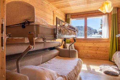 pokój z 2 łóżkami piętrowymi w drewnianym domku w obiekcie Chalet Mountainside avec sauna et jacuzzi à 200m des pistes w mieście Vars