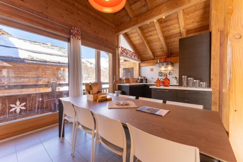 une cuisine avec une grande table et des chaises en bois dans l'établissement Chalet Mountainside avec sauna et jacuzzi à 200m des pistes, à Vars