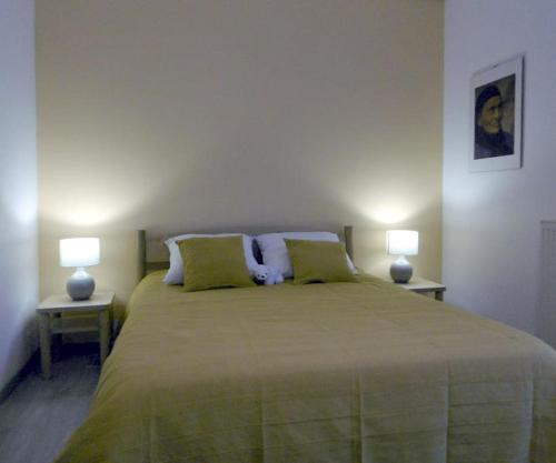 - une chambre avec un grand lit et deux lampes dans l'établissement Bienvenue au gîte de Claret, à Casseneuil