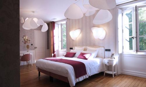 a bedroom with a white bed with hearts on the wall at Château de Crespy & Suites 