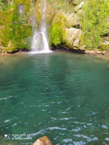 a waterfall in the middle of a pool of water at Vodenica Lug in Strmosten