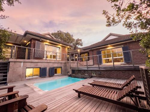 Casa con piscina y terraza con bancos en 10 St Andrews Avenue en Natureʼs Valley