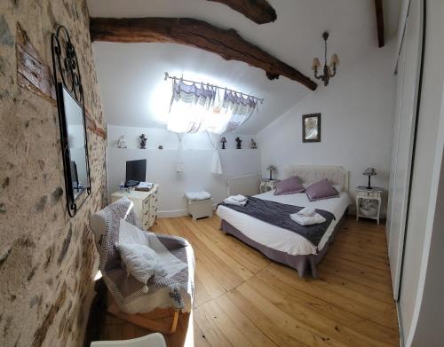 ein Schlafzimmer mit einem Bett und einem Stuhl in einem Zimmer in der Unterkunft Les hauts Brianço in Solignac