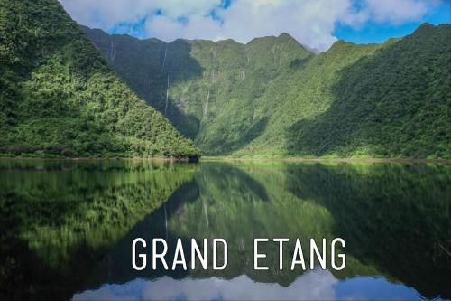 a mountain reflecting in a lake with the words grand ending at STUDIO Le vent qui chuchote in Saint-Benoît