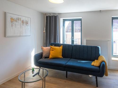 馬爾喬的住宿－HafenApartment im Herzen von Malchow，客厅配有蓝色沙发,设有玻璃桌