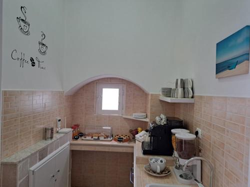 een kleine keuken met een spoelbak en een aanrecht bij B&B Casa Denittis in Peschici