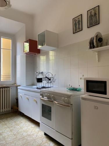 a kitchen with white cabinets and a stove top oven at Clara Luna appartamento turistico in Osimo