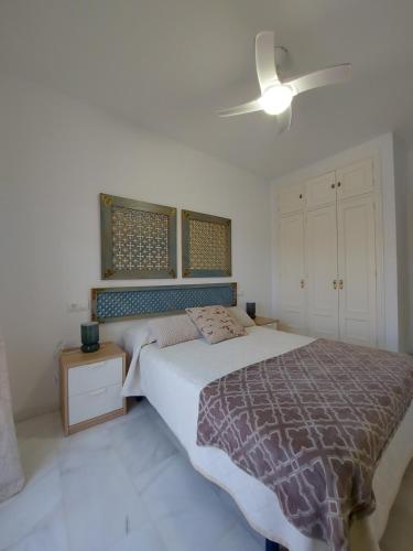 1 dormitorio con 1 cama y ventilador de techo en Apartamento Maria, en Chiclana de la Frontera