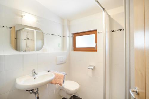 a bathroom with a sink and a toilet and a shower at Haus Rosengarten in Tirolo