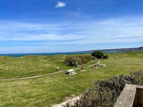 a grassy hill with people sitting in the grass at Camping De Collignon in Cherbourg en Cotentin
