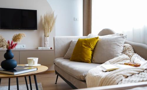 a living room with a white couch and a table at Tolevski Apartments, Bitola in Bitola