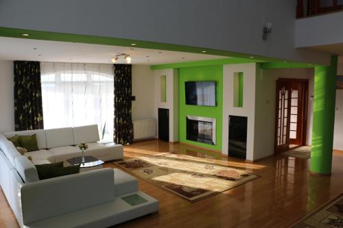 a living room with a white couch and green walls at Sanderson Apartments in Miercurea-Ciuc