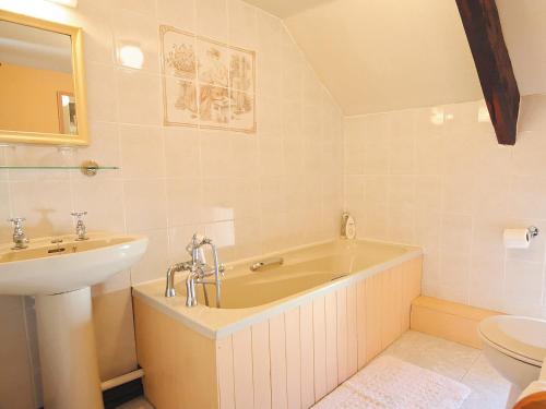 a bathroom with a tub and a sink and a toilet at Gamekeepers Cottage - Hw7729 in Myddfai