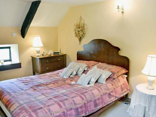 a bedroom with a bed with pillows on it at Gamekeepers Cottage - Hw7729 in Myddfai