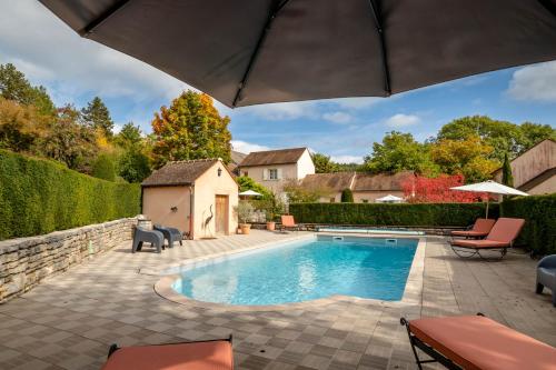 - une piscine dans un jardin avec des chaises et un parasol dans l'établissement Domaine De La Combotte, à Nantoux