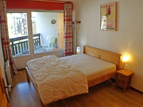 une chambre avec un lit et un balcon dans l'établissement Appartement lumineux au dernier étage, 3 pièces, centre de Samoëns, proche commerces et navette ski - FR-1-629-23, à Samoëns