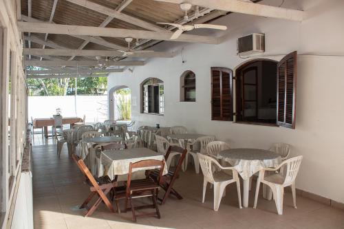 un restaurante con mesas y sillas en una habitación en Pousada Pérola do Guarujá Ltda- Me en Guarujá