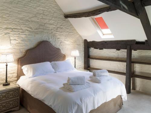 - une chambre dotée d'un grand lit avec des draps et des oreillers blancs dans l'établissement The Long Barn, à Ampney Crucis