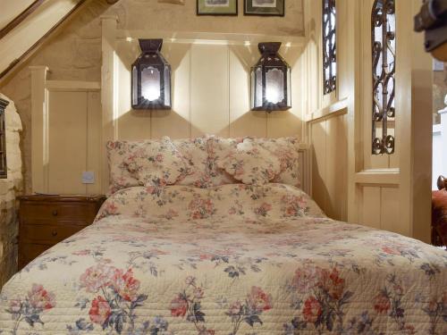 a bed in a bedroom with two lights on the wall at The Hayloft - Igp in Glaisdale