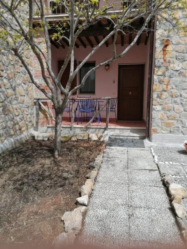 a tree in front of a building with a door at Il Casale di Luna in Saturnia