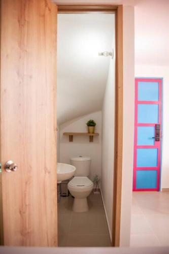 a bathroom with a white toilet and a staircase at Apartamento amplio cerca al parque Guatape - Pajaros in Guatapé