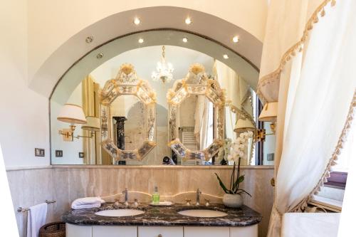 uma casa de banho com dois lavatórios em frente a um espelho em Villa Liberty a soli 20km da Venezia em Mira