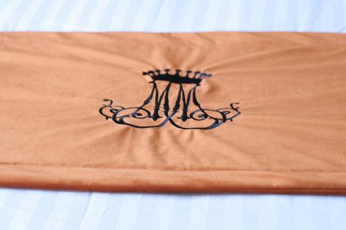 a orange blanket with a black design on it at Château de Crespy & Suites in Crespy-le-Neuf