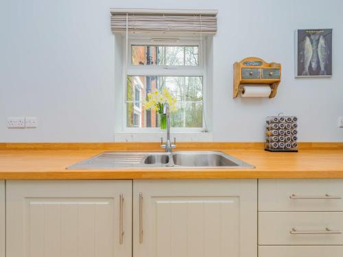 a kitchen counter with a sink and a window at Gardeners Cottage in Kiddemore Green