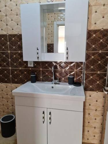 ein Badezimmer mit einem weißen Waschbecken und einem Spiegel in der Unterkunft Airport Budget Inn in Arnavutköy