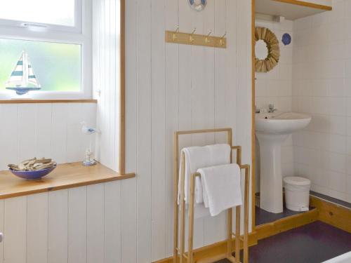 a bathroom with a sink and a toilet and a sink at Minallt in Nefyn
