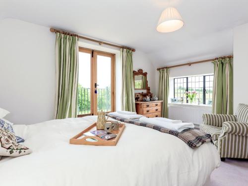 a bedroom with a white bed and a window at Cotswolds Farm in Miserden